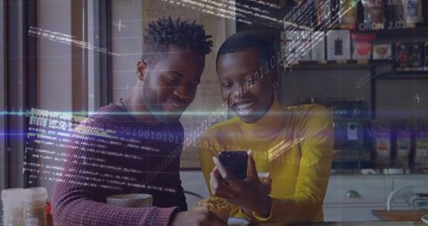 Smiling couple sharing smartphone at cafe with coffee and floating binary code overlay