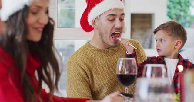 Family Enjoying Christmas Meal, Child Feeding Father - Download Free Stock Images Pikwizard.com