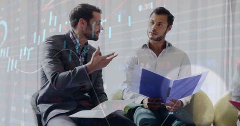 Business colleagues discuss financial reports with data overlays