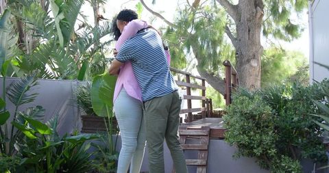 Young Couple Engaging in Romantic Proposal Amidst Lush Garden Setting
