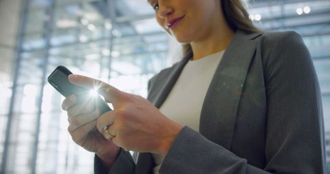 Businesswoman Using Smartphone in Sunny Office Atrium - Download Free Stock Images Pikwizard.com