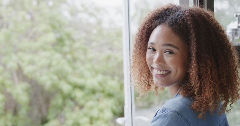 Smiling Woman by Window Enjoying Calm Indoors