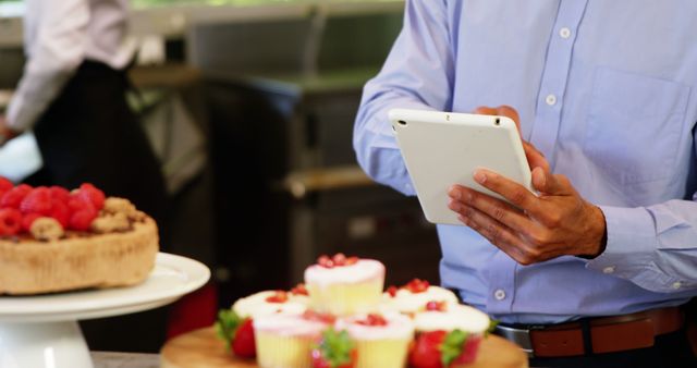 Pastry chef checking digital tablet for recipes in kitchen - Download Free Stock Images Pikwizard.com