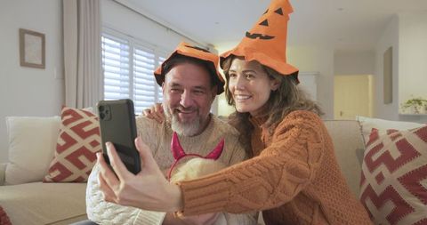 Happy Couple Taking Halloween Selfie with Themed Hats