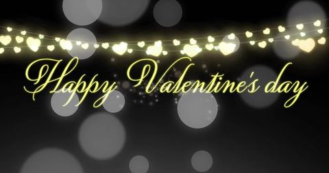 Glowing neon-yellow happy valentine's day cursive typography with heart bokeh lights