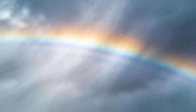 Iridescent Rainbow Arc Stretching Through Rain and Mist With Secondary Bow and Prismatic Glow
