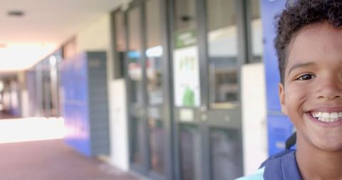 Smiling Child Outside School Entrance Awaits New Day