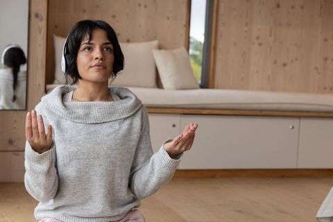 Woman practicing mindfulness meditation wearing headphones