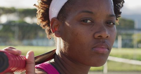 Determined female tennis player holding racket outdoors