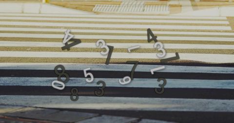 Floating numerals over striped urban crosswalk in daylight