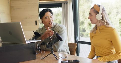 Recording podcast with diverse cohosts in bright home studio modern mics and collaboration