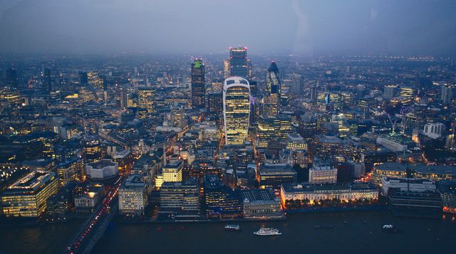 Illustrates the vibrant life of London with a vibrant aerial view taken at dusk. Useful for presentations, websites, marketing materials showing dynamic city life or for projects focusing on urban development, tourism, and architecture themes.