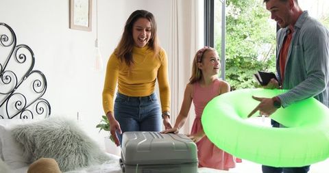 Family Packing for Summer Vacation in Cozy Bedroom