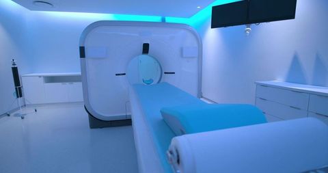 High-tech ct scanner room with blue ambient lighting, patient table, modern radiology interior