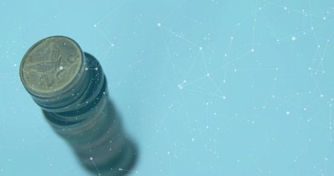 Stack of coins with digital technology overlay on blue background