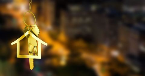 Golden House Keys Against Blurred Night City Background