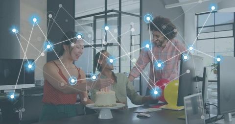 Office team celebrating birthday around desk with cake and glowing digital network overlay