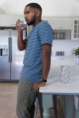 Man Enjoying Refreshing Drink in Modern Kitchen Interior