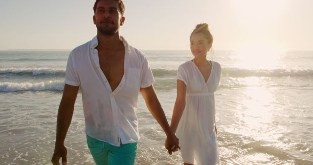 Biracial couple enjoys a beach sunset, with copy space. They share a romantic moment by the sea, reflecting a serene outdoor setting.