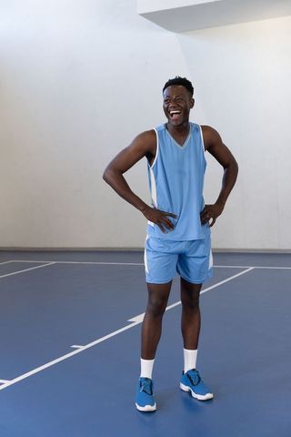 Joyful Basketball Player Laughing on Indoor Court