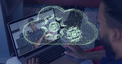 Using laptop displaying holographic cloud with gears representing remote collaboration