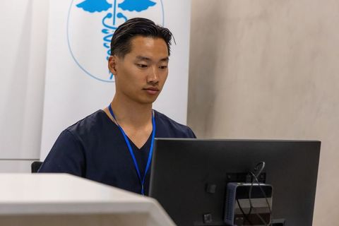 Healthcare professional working at clinic computer station checking patient records