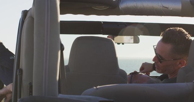 Man driving convertible near ocean on sunny day - Download Free Stock Images Pikwizard.com