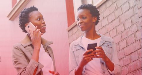 Smiling African American Women Connect with Smartphones Outdoors