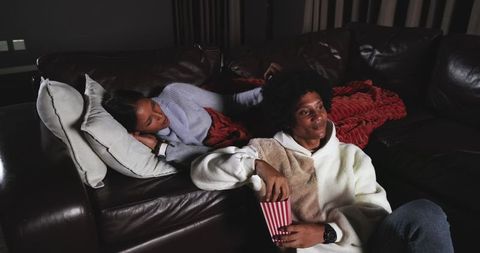 Cozy Night In: Couple Relaxing on Couch with Popcorn