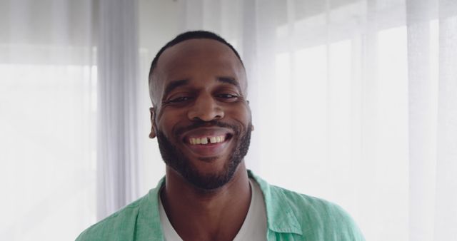 Cheerful Man Smiling in Bright Room with Sheer Curtains - Download Free Stock Images Pikwizard.com