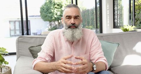 Senior Man Relaxing on Sofa in Sunlit Living Room