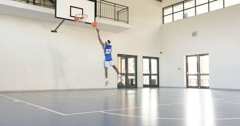 Basketball Player Performing Layup on Indoor Court
