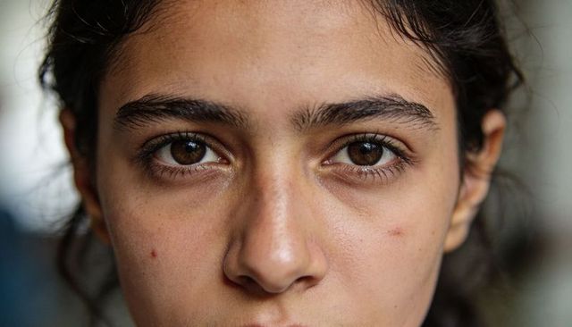 Gazing teenage female closeup showing natural skin texture and brown eyes