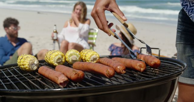 Friends Enjoying Beach Barbecue with Hot Dogs and Corn - Download Free Stock Images Pikwizard.com