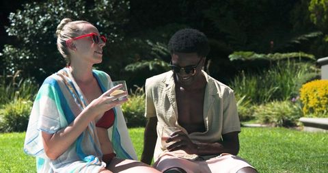 Diverse Couple Relaxing Outdoors Wearing Sunglasses