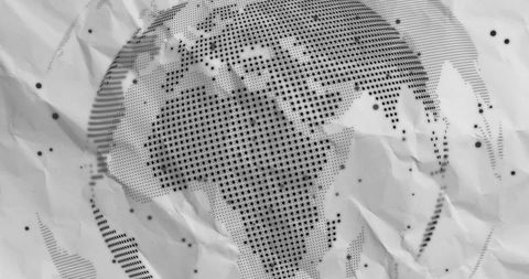 Crumpled halftone world map on textured paper surface