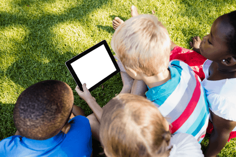 Children watching tablet on grass outdoors summer climate moments transparent