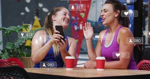 Active Women Engaging in Social Media Discussion at Cafe