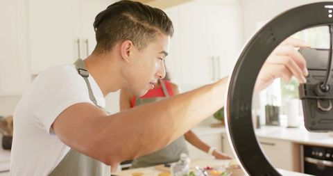 African American Presenter Adjusting Ring Light Camera While Preparing Meal for Livestream