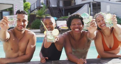 Diverse Group of Friends Toasting Drinks by Poolside