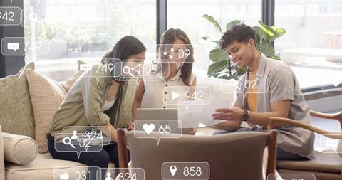 Young team collaborating in bright coworking lounge with social media engagement overlays