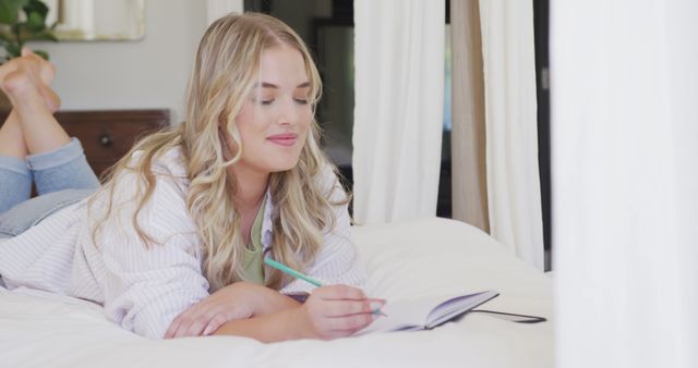 Young Woman Relaxing on Bed Writing in Notebook - Download Free Stock Images Pikwizard.com