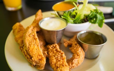 Crispy Fried Chicken Strips with Dipping Sauces and Salad Garnish