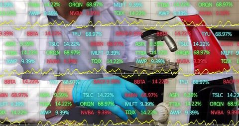 Lab technician operating microscope while financial data overlay charts market tickers