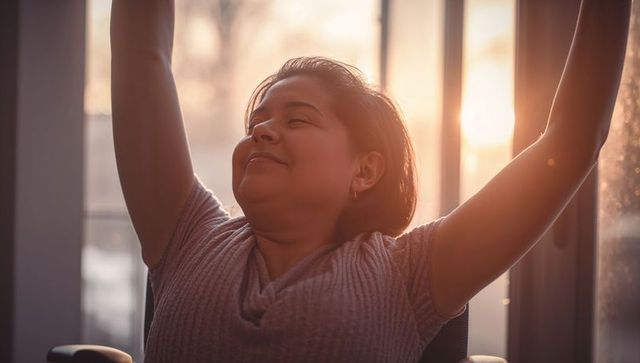 Woman stretching by window at sunrise relaxing morning stretch home wellness