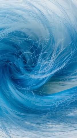 Vertical video of swirling blue synthetic fiber strands tightening into textile vortex