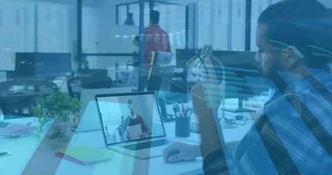 Man Drinking Water While Video Conferencing in Open-Plan Office