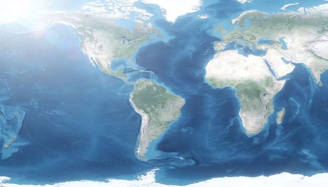 Equirectangular satellite world map showing continents, oceans, polar ice, sunlight glare