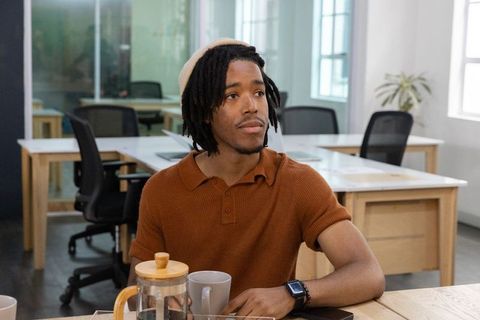 African american man enjoying coffee while working in modern coworking space