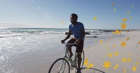Cycling along sunlit shoreline on vintage green bicycle with golden star confetti